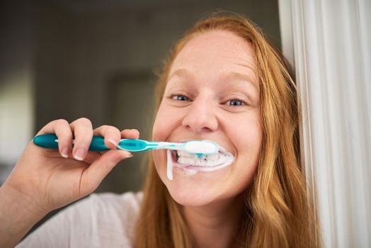 Complete clean when I brush my teeth. Shot of a young woman brushing her teeth at home.