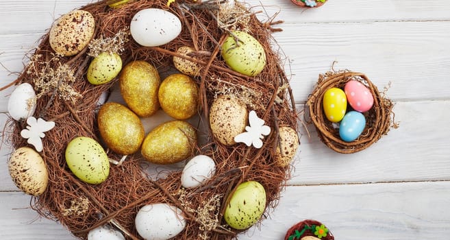 Coloeful easter eggs in nest on wood  background with space. Minimal concept. Card with copy space for text.
