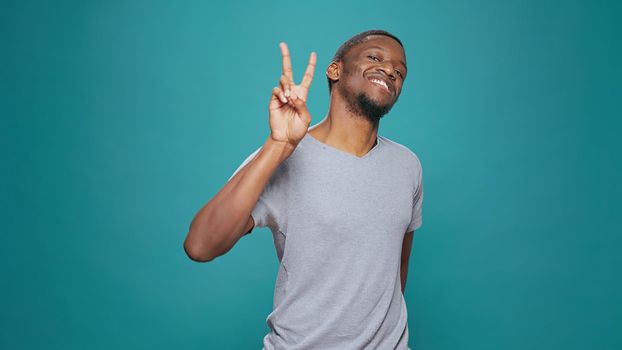 Positive model showing peace sign with hands on camera