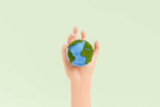 Hand with small planet Earth