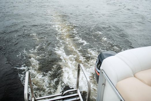 the stern of a motor boat with a bubbling trail