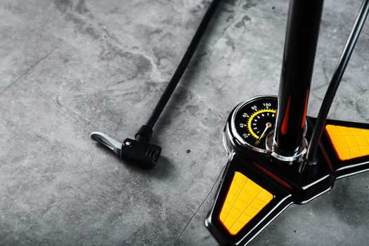 Air pump with a manometer and a wheel inflation hose on a dark background with free space