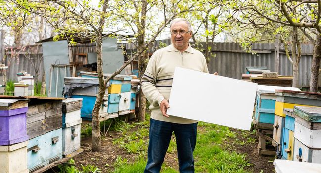 Smiling man holding a canva in garden
