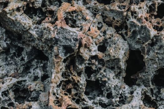 Abstract nature real photo background. Macro close up details dry rock crack stone solid foamy formations or lava volcanic frozen, pumice texture grain, ancient lunar style. Light gray orange basalt
