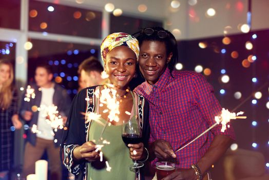 Let your celebrations sparkle with joy. Portrait of an attractive young couple having fun with sparklers at a nightclub.