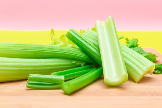 Fresh Celery Stem and Chopped Celery Sticks on Wooden Cutting Board