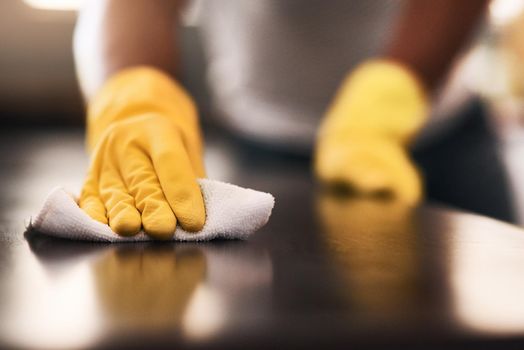 Keeping a germ-free home. Cropped shot of an unrecognizable man cleaning a kitchen counter at home.