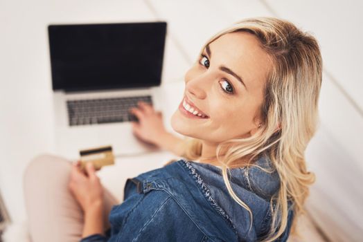 I prefer browsing stores online than at malls. Portrait of a young woman making a credit card payment on a laptop at home.