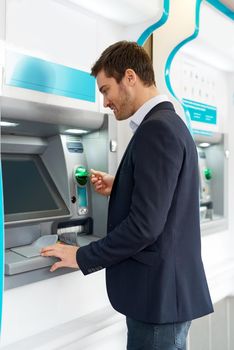 Making a quick cash withdrawal. Cropped shot of a young businessman making a transaction at an ATM.