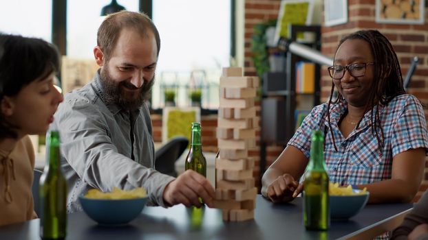 Male player losing at society game with wooden tower on table