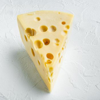 Maasdam cheese, on white stone surface, square format