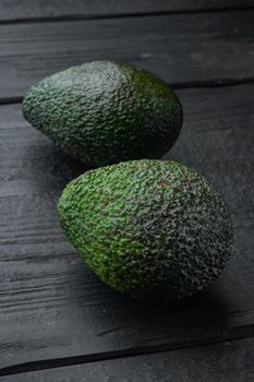 Ripe pair of green avocado, on black wooden background
