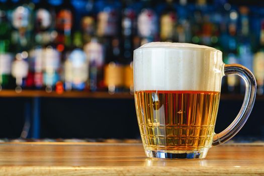 Fresh cold beer in glass on bar background
