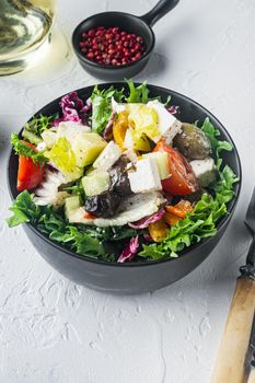 Greek salad with tomato, pepper, olives and feta cheese, on white background