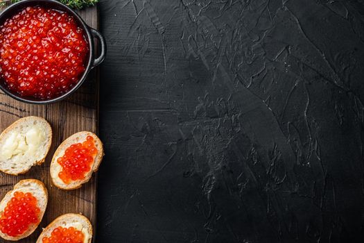 Canape with Red Salmon Caviar for New Year, on black background, top view flat lay with copy space for text