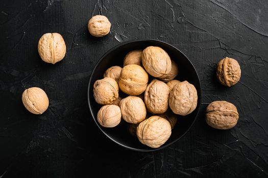 Walnut whole nut, on black dark stone table background, top view flat lay