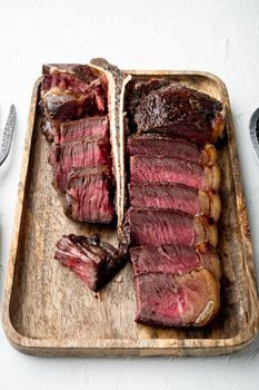 American cuisine. Sliced and roast T-bone or porterhouse beef medium rare meat Steak, on white stone background
