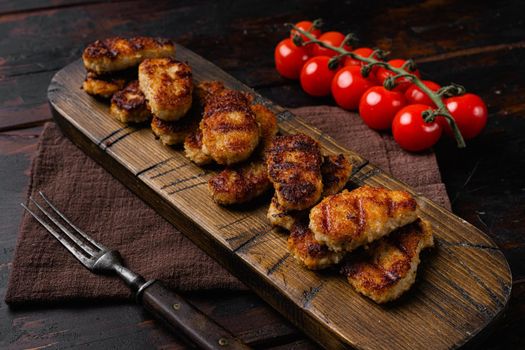Fried crispy chicken nuggets, on old dark wooden table background