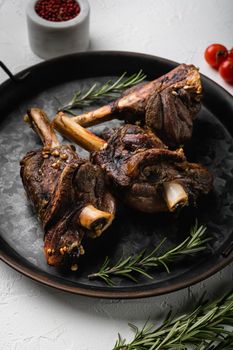 Braised Lamb Shanks with Sauce and Herbs, on white stone table background