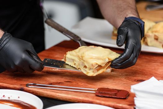 Francesinha, traditional Portuguese sandwich originally from Porto. National cuisine concept. the chef prepares a dish at restaurant