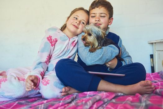 Puppy will always be our best pal. Shot of two young siblings bonding with their pet dog at home.