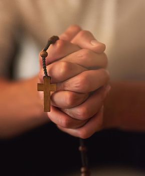 Prayer is the best armor against all trials. Cropped shot of a man holding a rosary and praying.
