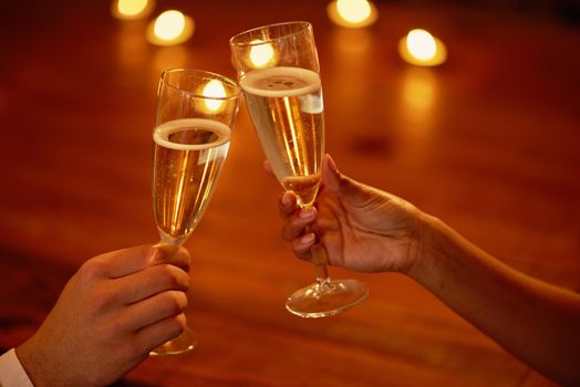 Heres to us. Shot of an unidentifiable couple toasting with champagne.