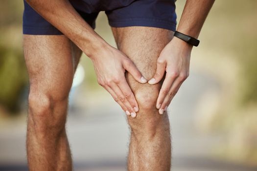 Ive reached my limit now. Closeup shot of an unrecognisable man holding his knee in pain while exercising outdoors.
