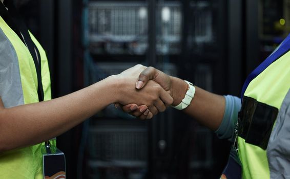Youve got a deal. Cropped shot of two unrecognizable female programmers shaking hands in a server room.