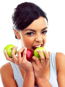 Munching on the healthy stuff. Studio portrait of a young woman in gymwear holding apples.