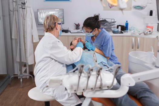 Specialist orthodontist team checking man danture