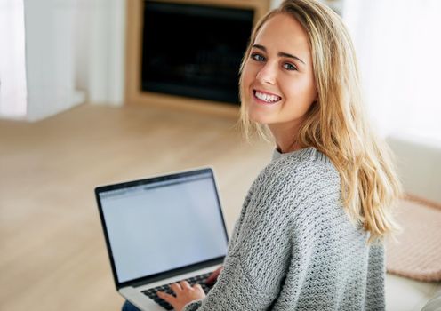 Blogging is great. High angle portrait of an attractive young woman using her laptop at home.