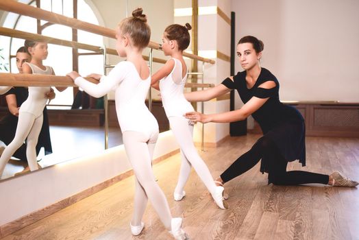 Girls are engaged in choreography in the ballet school.Young ballet teacher and