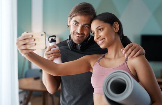 Status update Workout completed. Cropped shot of an athletic young couple taking selfies before starting their workout at home.