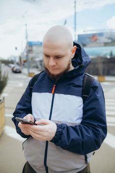 Young irish man smiling happy using smartphone at the city.