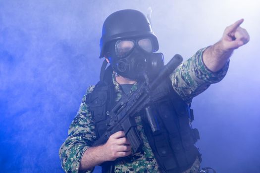 Soldier holding assault rifle in smoky haze