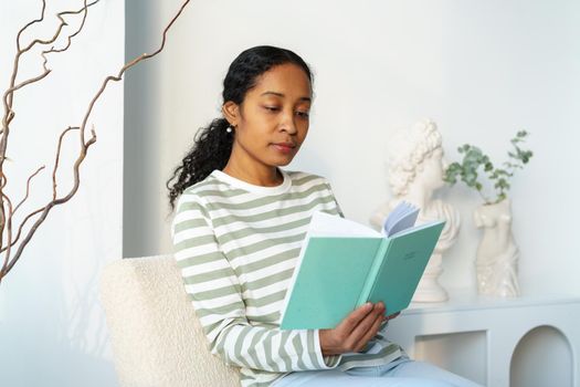 African-american woman peacefully reading book in spare time. Digital detox. Slow living lifestyle