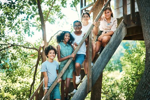 Happy campers live here. Shot of a group of teenagers standing next to a treehouse at summer camp.