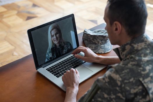 Soldier works on his laptop.