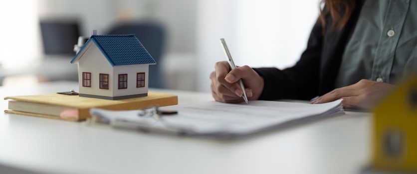 Close up hand of real estate investment and home insurance signing contracts in accordance with the home buying insurance agreements approving purchases for clients