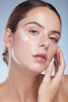 Your skincare is in your hands. Studio portrait of an attractive young woman moisturizing her face against a grey background.