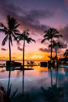 sunset tropical pool with palm trees, sunset by the pool with palm trees during vacation in Mauritius