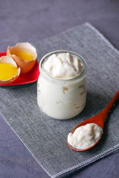 Mayonnaise in container , oil and eggs on table