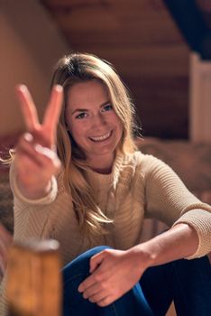 Peace is a mindset. Portrait of a young woman giving a peace sign while relaxing in her bedroom at home.