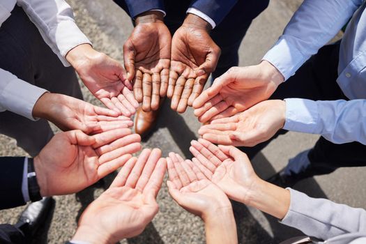 Communication among go-getters. Shot of a group of unrecognizable businesspeople joining their hands together outside.