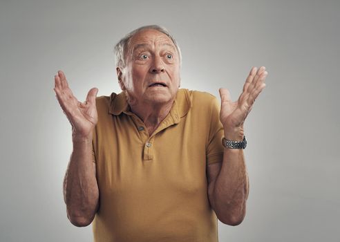 I did not see that coming. Studio of an elderly man in disbelief against a grey background.