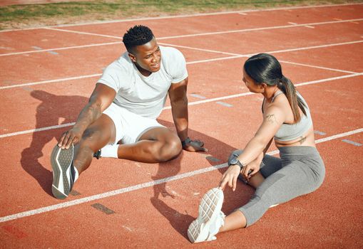 Theyre warming up to the task. High angle shot of a young athletic couple warming up before starting their outdoor exercise routine.