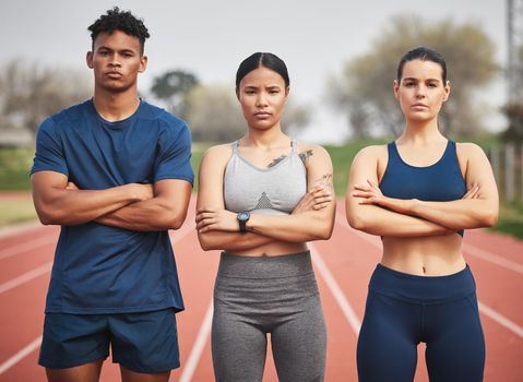 Youre witnessing the winning team. Cropped portrait of three young athletes standing outside with their arms folded.
