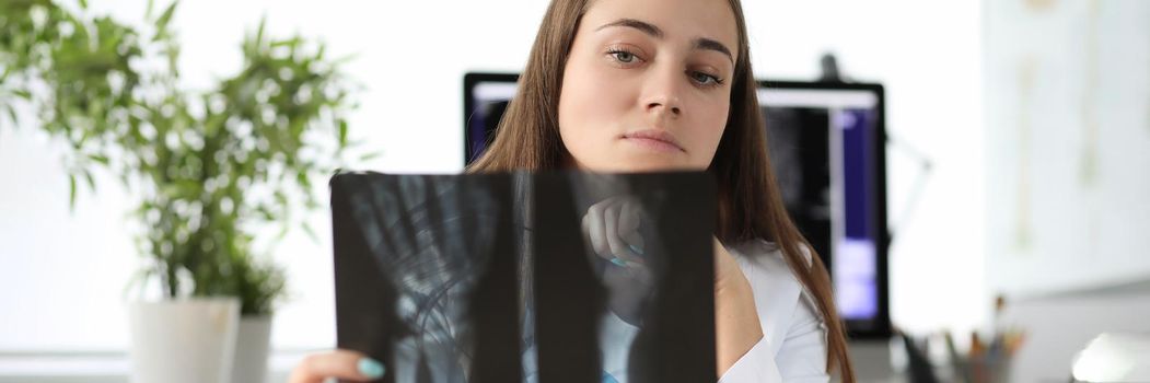 Doctor carefully examining xray of patient hand in clinic