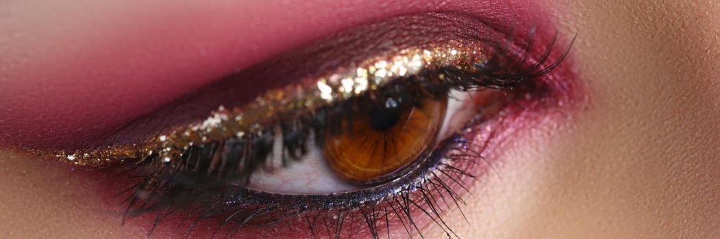 Closeup of female eye with bright pink makeup